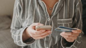 a woman shopping online using her mobile phone and paying with her creditcard.